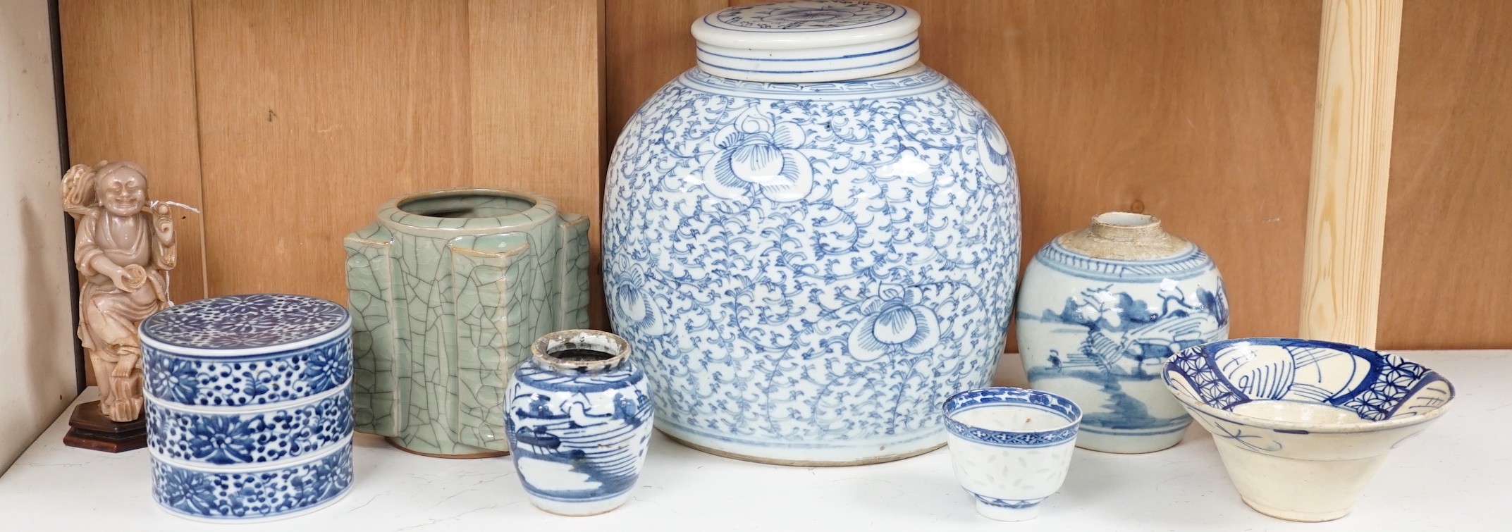 A group of 19th century blue and white jars, a stacking food box and two bowls, together with a celadon glazed cong vase and a soapstone figure of Liu Hai. Tallest 24cm